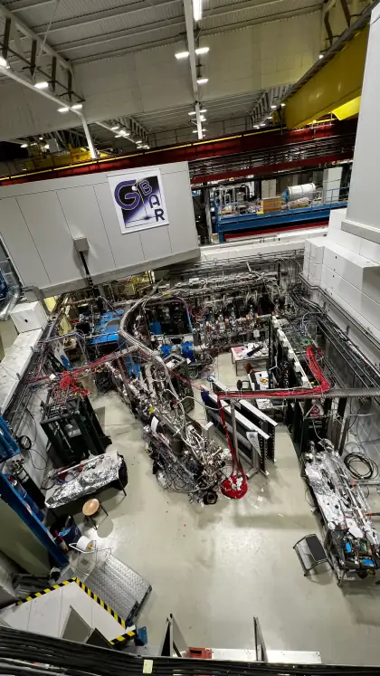 An experiment hall seen from above, with a GBAR logo on the wall